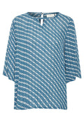 Blaue Bluse mit lockerer Passform, kurzen Ärmeln und einem Schlüsselloch-Ausschnitt. Mit einem weißen abstrakten Muster durchzogen. Glatte Textur.