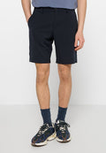 Marineblaue Shorts aus leichtem Stoff, mit klassischem Design, vorderen Taschen und glatter Textur. Getragen mit gemusterten Socken und Sneakern.