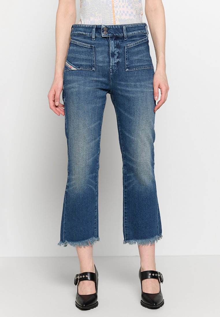 Denim-Jeans in mittlerem Blau mit einem kurzen, ausgestellten Design. Verfügt über zwei Fronttaschen und fransige Säume, gefertigt aus weichem, strukturiertem Stoff.