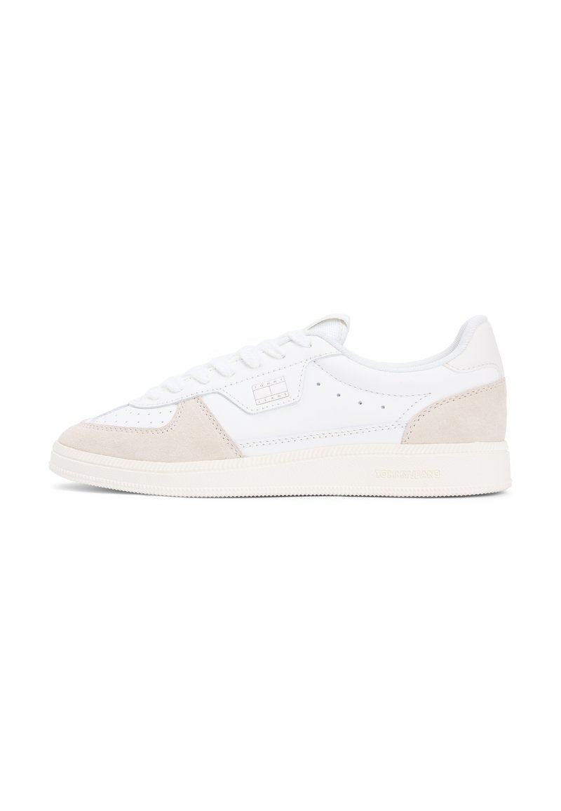 Weißer Sneaker mit beigen Wildledereinsätzen. Verfügt über ein niedriges Profil, flache Sohle, Schnürsenkel vorne und perforierte Details an den Seiten.