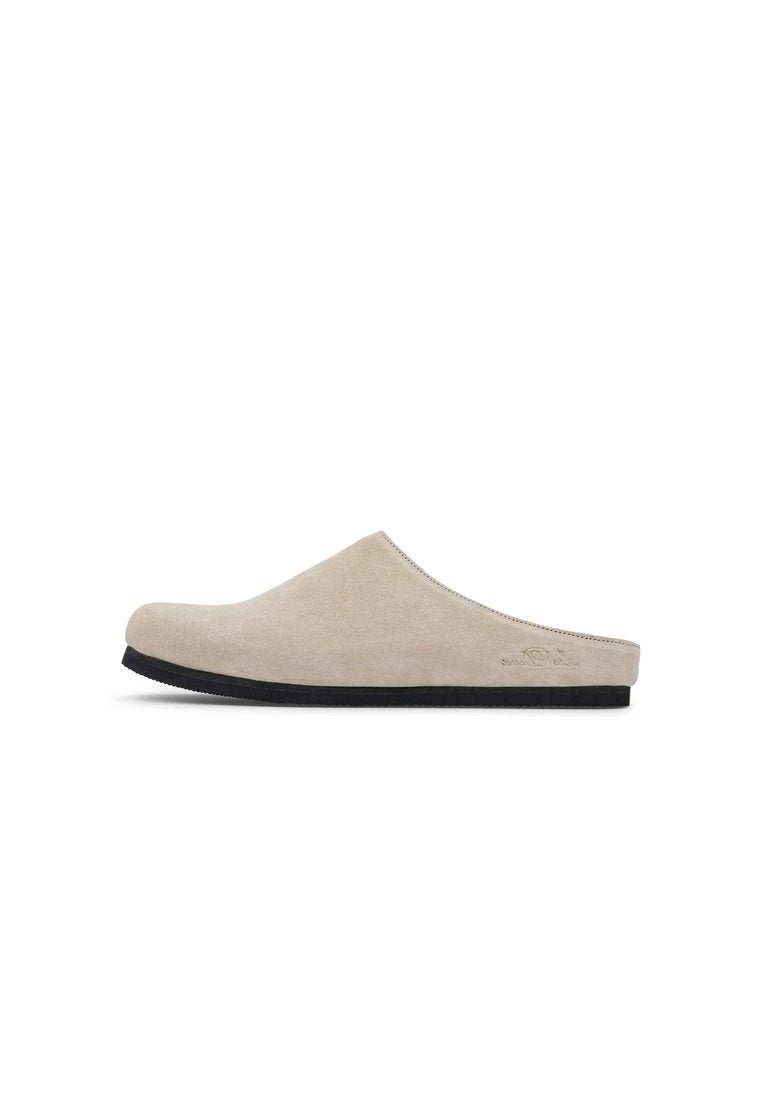 Beiger Wildleder-Slipper mit niedrigem Profil und schwarzer Gummisohle. Verfügt über eine glatte Textur und minimale Nähte für ein sauberes Design.