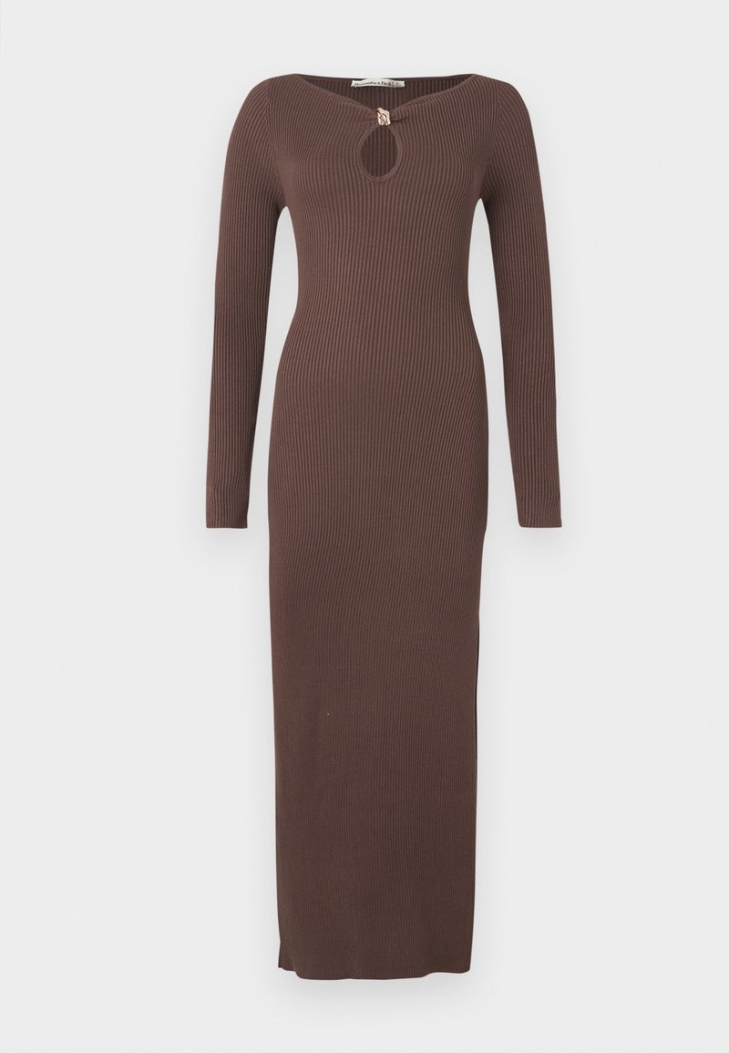 Langes, geripptes braunes Kleid mit Schlitz am Ausschnitt, langen Ärmeln und seitlichen Schlitzen. Hergestellt aus einem strukturierten Stoff, figurbetonte Silhouette.