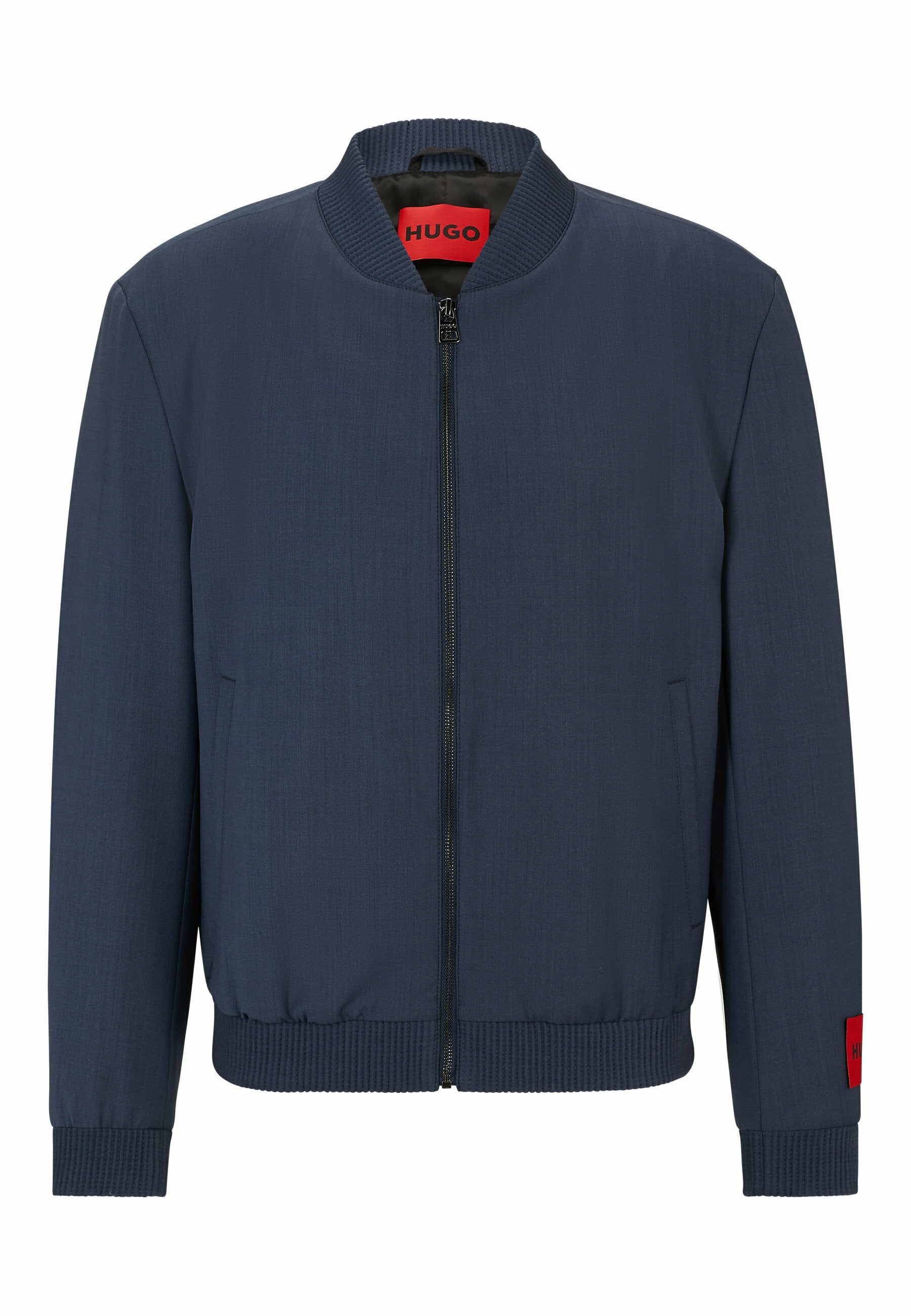 Marineblaue Bomberjacke mit geripptem Kragen, Bündchen und Saum, Frontreißverschluss, seitlichen Taschen und roten Hugo-Markenetiketten am inneren Kragen und am Ärmel.