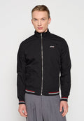 Schwarze Zip-Jacke mit hohem Kragen, die ein kleines Logo auf der Brust trägt. Gerippte Bündchen und Saum mit roten und weißen Streifen. Glatte Textur.