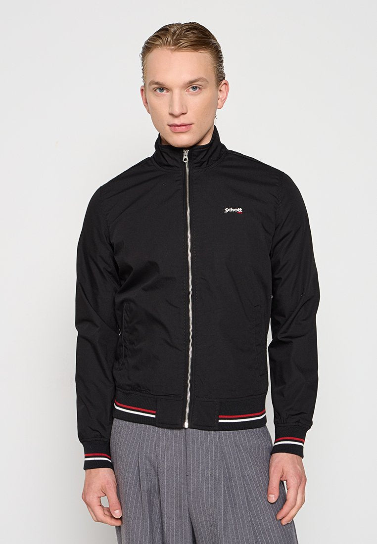 Schwarze Zip-Jacke mit hohem Kragen, die ein kleines Logo auf der Brust trägt. Gerippte Bündchen und Saum mit roten und weißen Streifen. Glatte Textur.