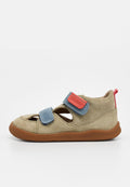 Beige Wildleder-Kindersandale mit brauner Sohle, blauen und roten verstellbaren Klettverschlussriemen sowie offenen Zehen- und Fersenbereichen.