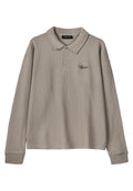 Helles graues Poloshirt mit Waffelstruktur und langen Ärmeln, mit drei Knöpfen und einem gerippten Kragen. Mit schwarzem gesticktem Logo auf der Brust.