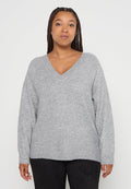 Grau gestrickter Pullover mit V-Ausschnitt, langen Ärmeln und lockerer Passform. Strukturiertes Gewebe mit einem subtilen Muster, der Saum sitzt knapp unter der Taille.