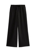 Schwarze weite Hose mit weißen vertikalen Streifen, mit einem elastischen Bund und Kordelzug. Glatte Stofftextur, lässiges Design.