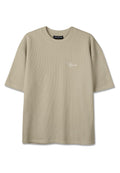 Beiges kurzärmliges T-Shirt mit Rippstruktur, Rundhalsausschnitt und kleinem weißen "Pegador"-Logo auf der linken Brust.