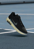 Nike Sneakers aus schwarzem Mesh mit einem grauen Swoosh, ausgestattet mit einer halbtransparenten gelben Sohle, die für den sportlichen Einsatz konzipiert sind.