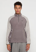 Grauer Fleece-Pullover mit langen hellgrauen Ärmeln, Halbzipper und frontaler Tasche. Verfügt über ein kleines Logo auf der Brust und elastische Bündchen.