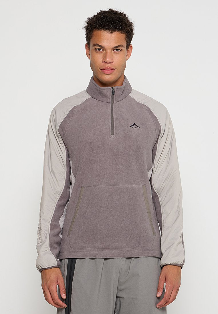 Grauer Fleece-Pullover mit langen hellgrauen Ärmeln, Halbzipper und frontaler Tasche. Verfügt über ein kleines Logo auf der Brust und elastische Bündchen.