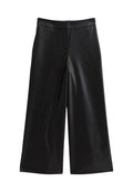 Schwarze, weite Hosen mit hoher Taille und glatter, lederähnlicher Textur, ausgestattet mit seitlichen Taschen und einem verdeckten Frontverschluss.