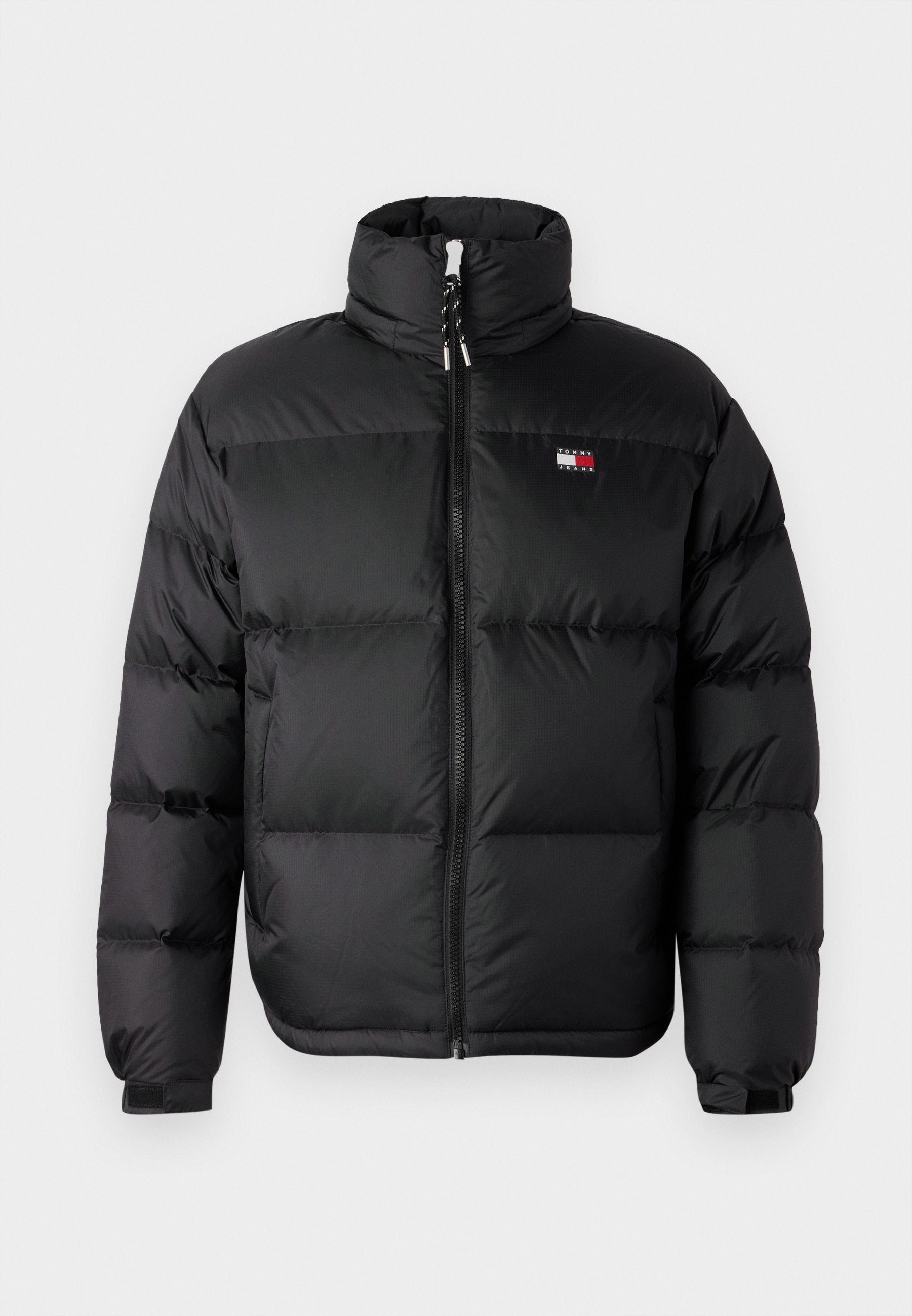 Schwarze Pufferjacke mit hohem Kragen, vorderem Reißverschluss und horizontalen Steppnähten. Verfügt über ein kleines Logo auf der Brust.