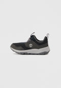 Schwarz-grauer Slip-On-Sneaker mit Zuglaschen, strukturierter Sohle und weißem Baumlogo an der Seite, von außen auf einfarbigem Hintergrund gezeigt.