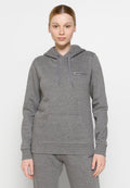 Frau steht frontal und trägt einen grauen Hoodie sowie passende Jogginghosen mit "PeakPerformance"-Logos auf beiden.