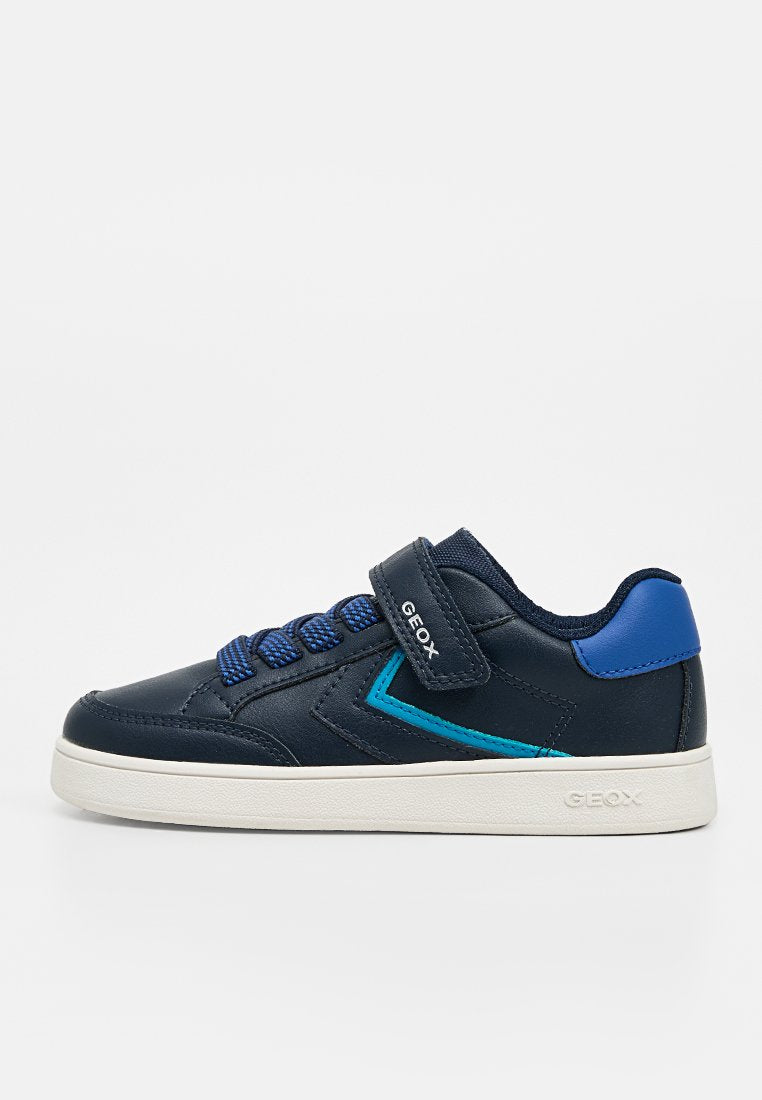 Kindersneaker in Marineblau mit blauen Akzenten, Klettverschluss, weißer Sohle und der "GEOX"-Markierung auf dem Riemen und der Sohle.