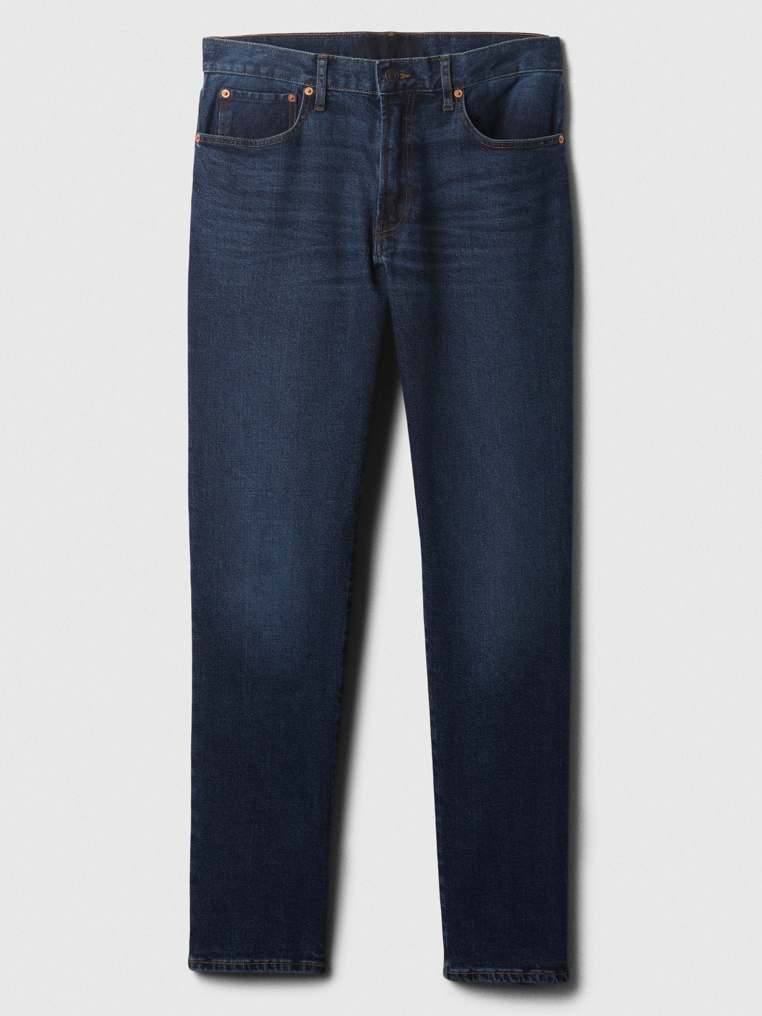 Dunkelblaue Slim-Fit-Jeans aus Denim mit leichtem Verblassen an den vorderen Oberschenkeln, Kupferriegeln und klassischem Fünf-Taschen-Stil, flach auf weißem Hintergrund ausgelegt.