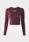 Maronenfarbener Langarm-Crop-Top aus dehnbarem Stoff, mit weißen Kontrastnähten und einem Nike-Logo auf der Brust, sowie taillierten Ärmeln.