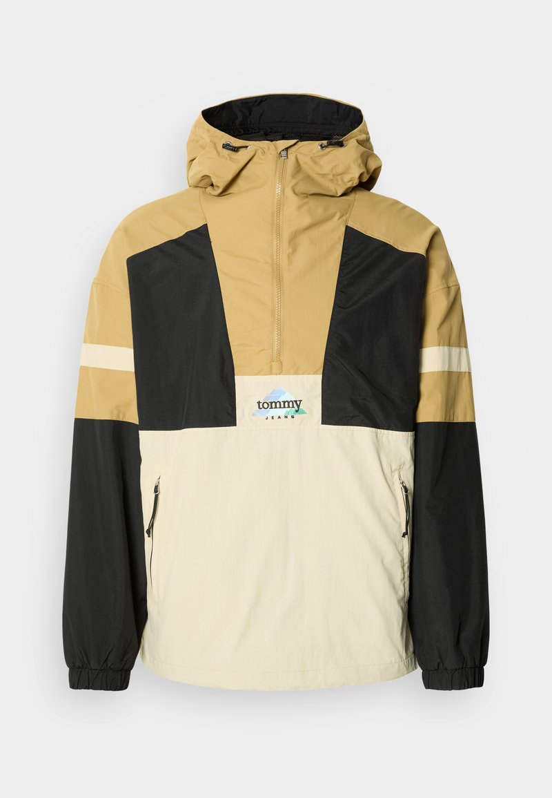 Windbreaker-Jacke in Beige, Schwarz und Creme. Verfügt über ein Viertel-Reißverschluss-Design, verstellbare Kapuze und seitliche Reißverschlusstaschen. Logo auf der Brust.
