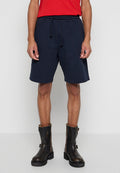 Marineblaue Baumwollshorts mit elastischem Bund, verstellbarem Kordelzug und Seitentaschen. Kombiniert mit braunen Stiefeletten.