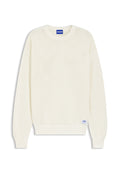 Cremefarbener, langärmeliger Strickpullover mit gerippten Bündchen und Saum, versehen mit einem blauen "HUGO"-Etikett am Halsausschnitt und am unteren Saum.
