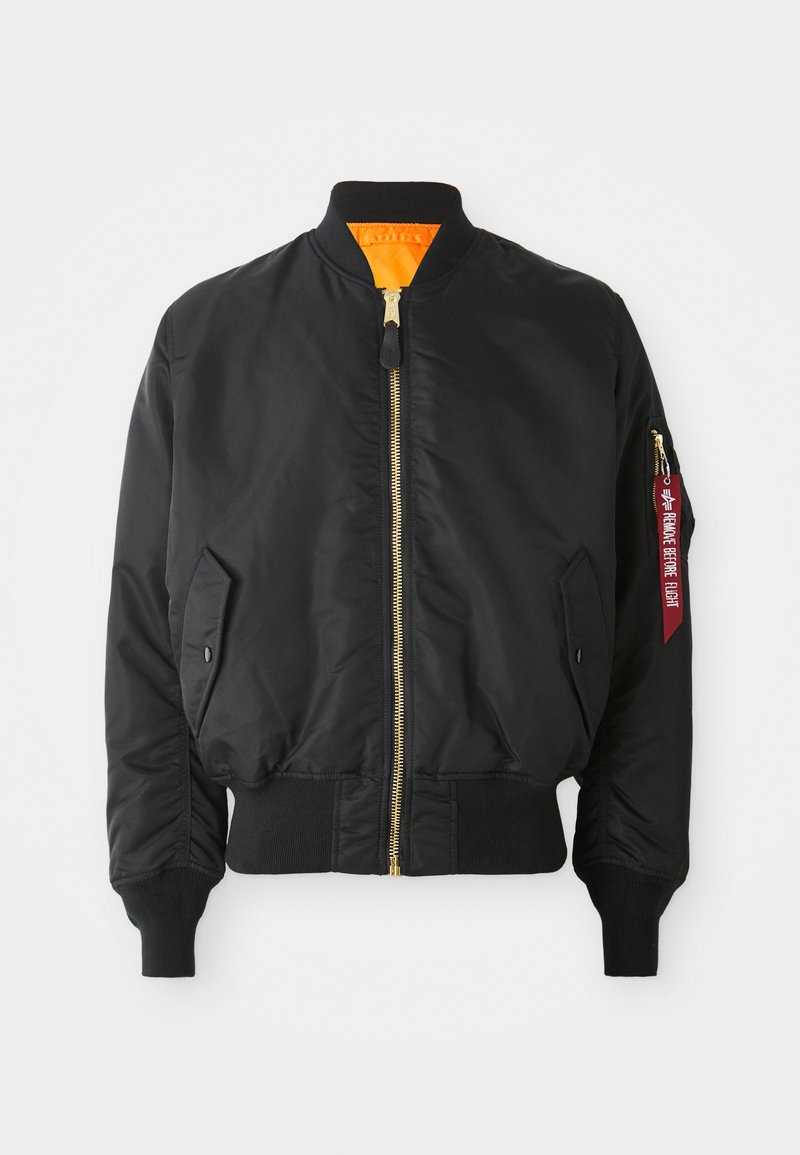 Schwarze Bomberjacke mit goldenem Reißverschluss, gerippten Bündchen und orangefarbener Innenauskleidung. Verfügt über eine Seitentasche und ein markiertes rotes Etikett am Ärmel.