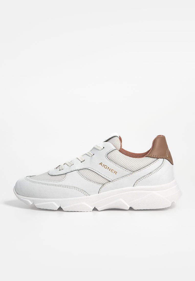 Weiße Sneaker aus Mesh- und Leder-Materialien, mit einem braunen Akzent an der Ferse und einer strukturierten Sohle, gestaltet für Komfort und Unterstützung.
