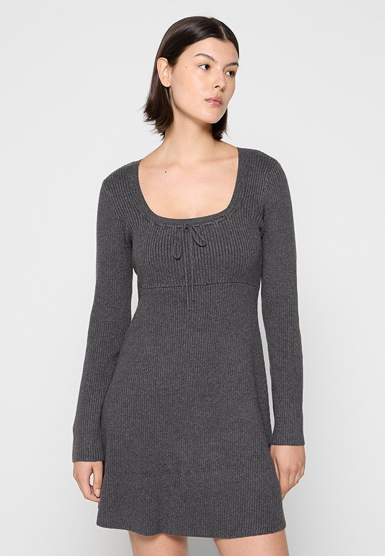 Graues geripptes Strickkleid mit quadratischem Ausschnitt, langen Ärmeln und verstellbarem Bindeband am Dekolleté. Weicher Stoff und ausgestellt geschnittene Säume.