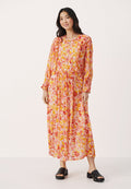 Florales Maxikleid in Pink-, Gelb- und Orangetönen. Lange Ärmel, geraffte Manschetten und eine taillierte Taille sorgen für eine fließende Silhouette. Schwarze Rutschen-Sandalen.