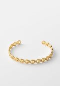 Goldenes offenes Manschettenarmband mit Kettenglieder-Design und kleinen eingesetzten klaren Steinen an jedem Glied, vor weißem Hintergrund.