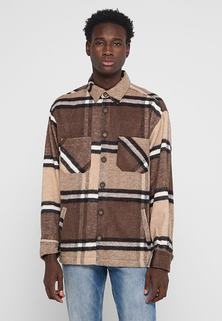Braun-beige karierter Flanellhemd mit Knopfverschluss, zwei Brusttaschen und langen Ärmeln. Mit kontrastierenden schwarzen Streifen.
