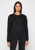 Schwarzer gestrickter Pullover mit rundem Ausschnitt und langen Ärmeln, mit einem strukturierten Muster und lässiger Passform, getragen zu dunklen Jeans.