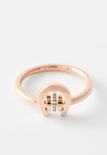 Ring aus Roségold mit minimalistischer Gestaltung, glattem Band, offener Bogen und drei eingelassenen klaren Steinen in der Mitte.