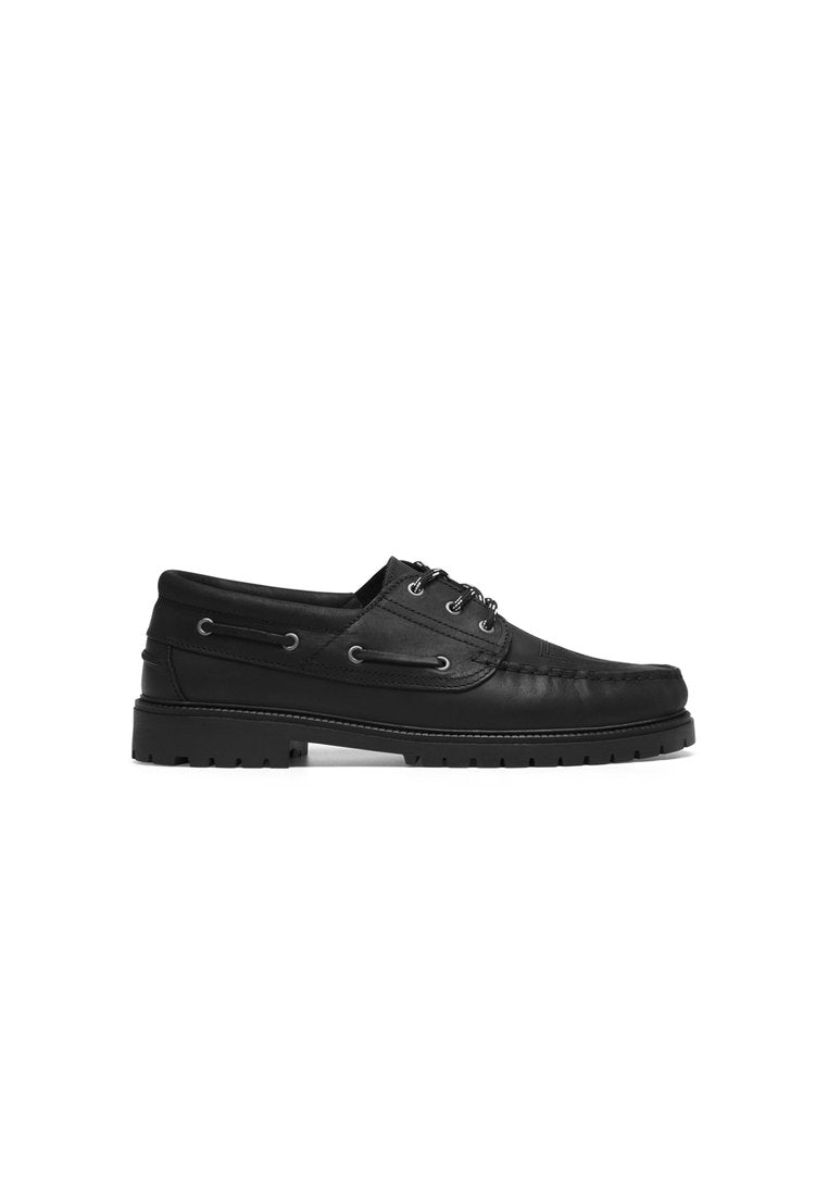 Schwarze Lederbootsschuhe mit abgerundeter Zehenpartie, strukturiertem Obermaterial, Schnürdesign und Gummisohle mit Traktionsrillen.