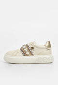 Beige Leder Sneaker mit goldenen Akzenten, dekorativen Riemen verziert mit Perlen und Nieten sowie einer strukturierten weißen Gummisohle.