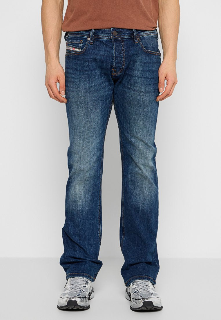 Dunkelblaue Jeans mit geradem Schnitt, leichter Ausbleichung an den Oberschenkeln und Kontrastnähten. Verfügt über Seiten- und Gesäßtaschen.