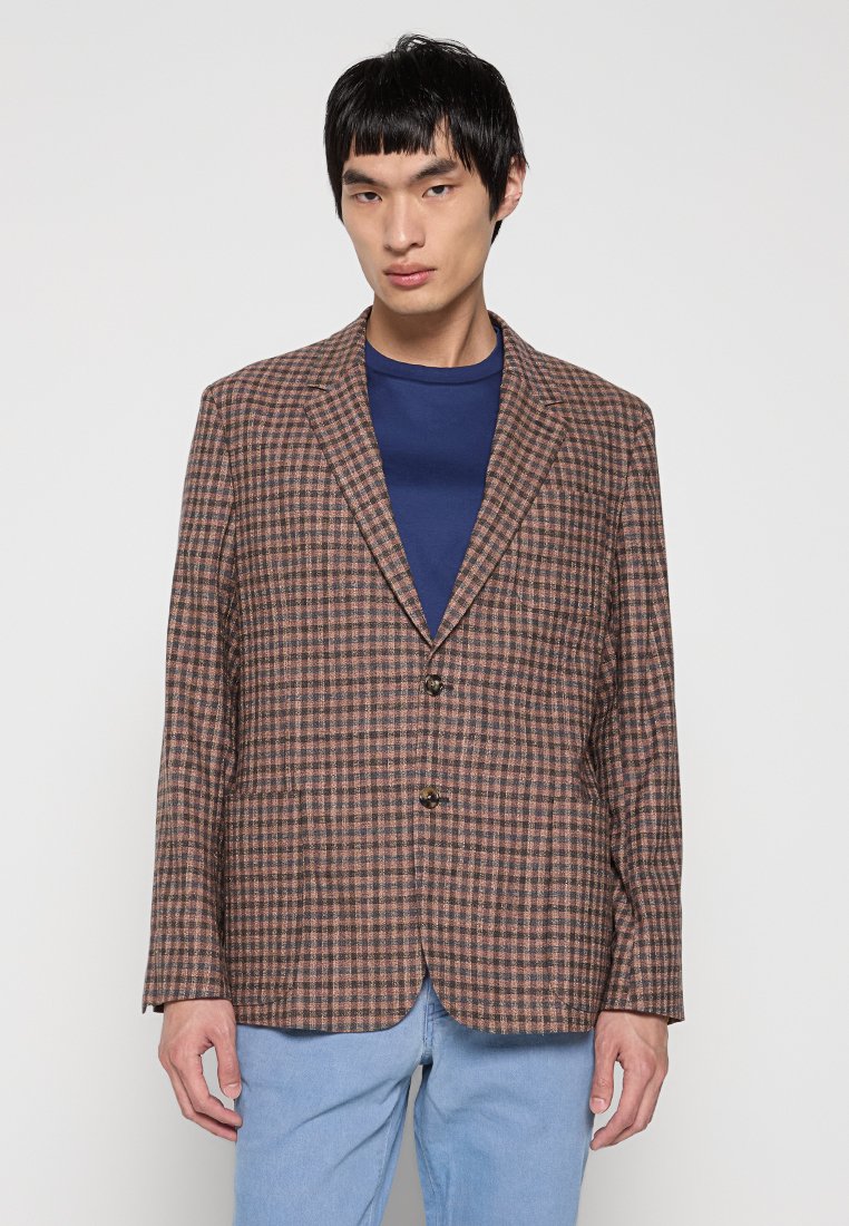 Braun-beige karierter Blazer mit zwei Knöpfen, Reverskragen und lockerer Passform, kombiniert mit einem blauen Rundhalsausschnitt-Shirt.