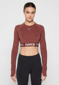 Bordeauxfarbene, langärmlige Cropped-Top mit Rundhalsausschnitt und "NIKE PRO"-Logoband am Saum. Weicher, elastischer Stoff mit körpernaher Passform.