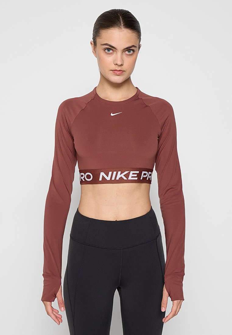 Bordeauxfarbene, langärmlige Cropped-Top mit Rundhalsausschnitt und "NIKE PRO"-Logoband am Saum. Weicher, elastischer Stoff mit körpernaher Passform.