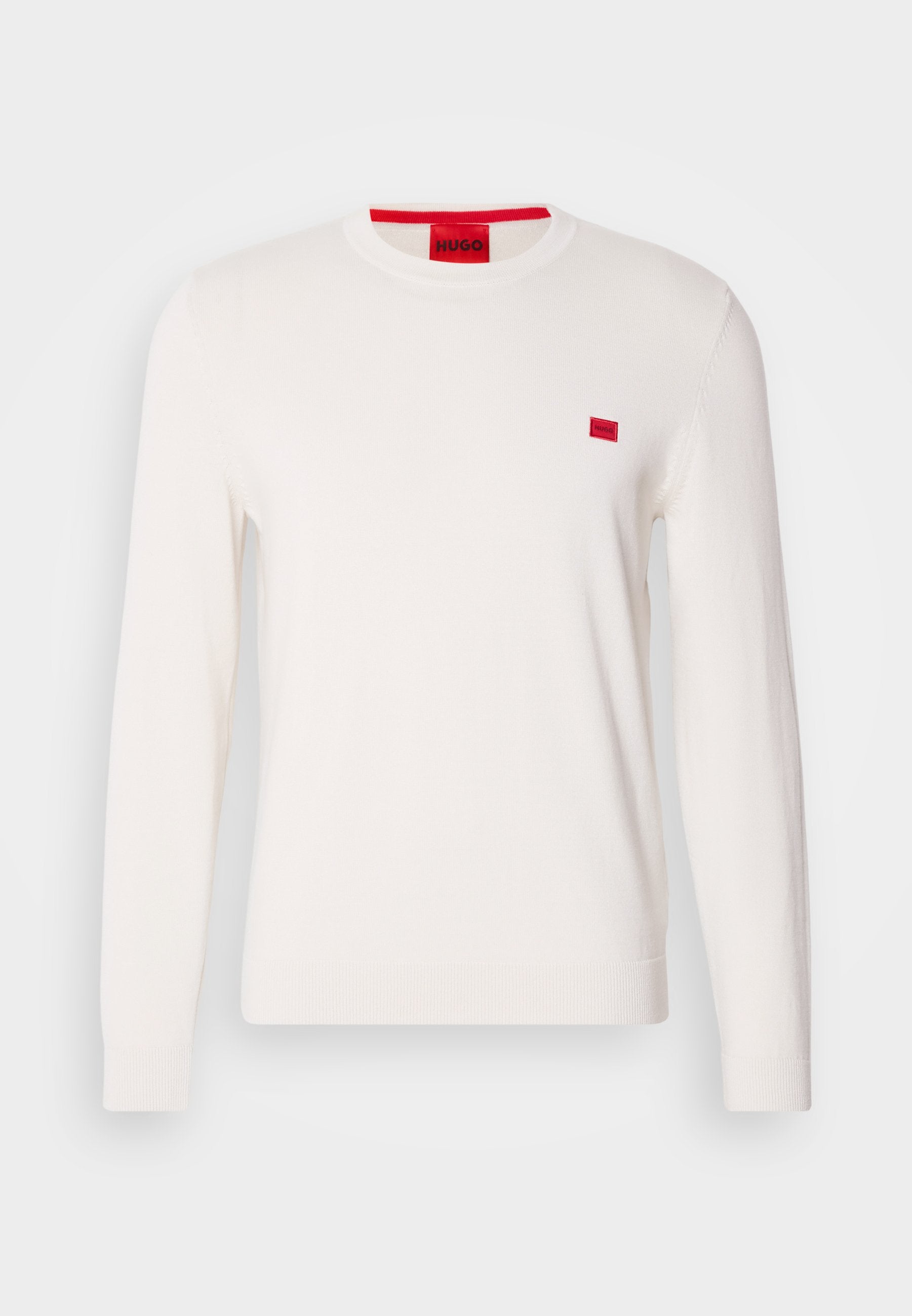 Weißer Rundhalsausschnitt-Pullover mit langen Ärmeln, aus weichem Stoff gefertigt. Verfügt über ein kleines rotes Logo-Patch auf der Brust und ein kontrastierendes rotes Etikett am Kragen.
