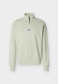 Hellgrüner Langarm-Pullover mit Viertelreißverschluss und blauem "HUGO"-Label, mittig unter dem Reißverschluss auf der Brust.
