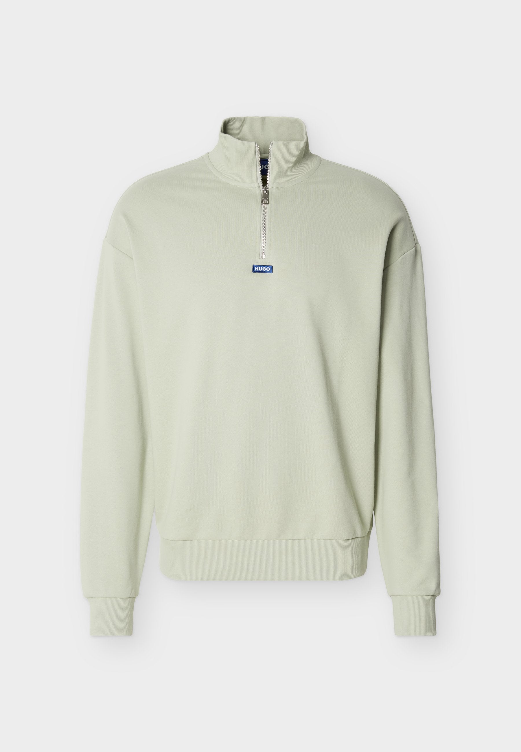 Hellgrüner Langarm-Pullover mit Viertelreißverschluss und blauem "HUGO"-Label, mittig unter dem Reißverschluss auf der Brust.