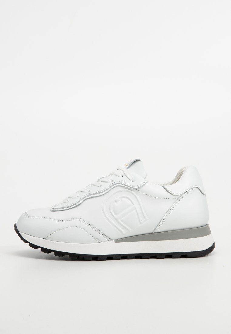 Weißes Leder-Sneaker mit abgerundetem Zehenbereich, Schnürverschluss, grauen Akzenten an der Mittelsohle und strukturiertem Sohlenbereich. Mit geprägtem Logo an der Seite.