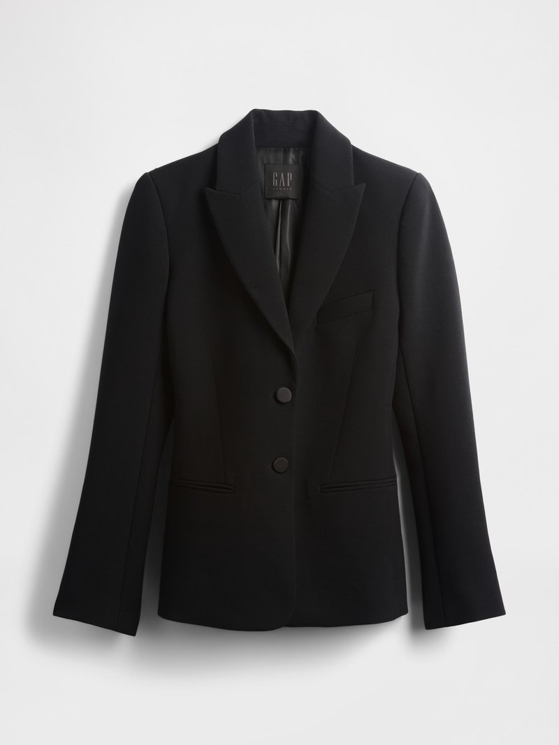 Schwarzer Blazer mit Reverskragen, zwei Knöpfen und einer einzelnen Brusttasche. Hergestellt aus einem glatten Stoff mit strukturiertem Schnitt und langen Ärmeln.