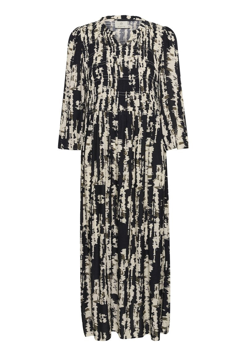 Maxikleid in Schwarz und Creme, mit einem Pinselstrichmuster. Lange Ärmel, runder Ausschnitt und geraffte Details in der Taille.