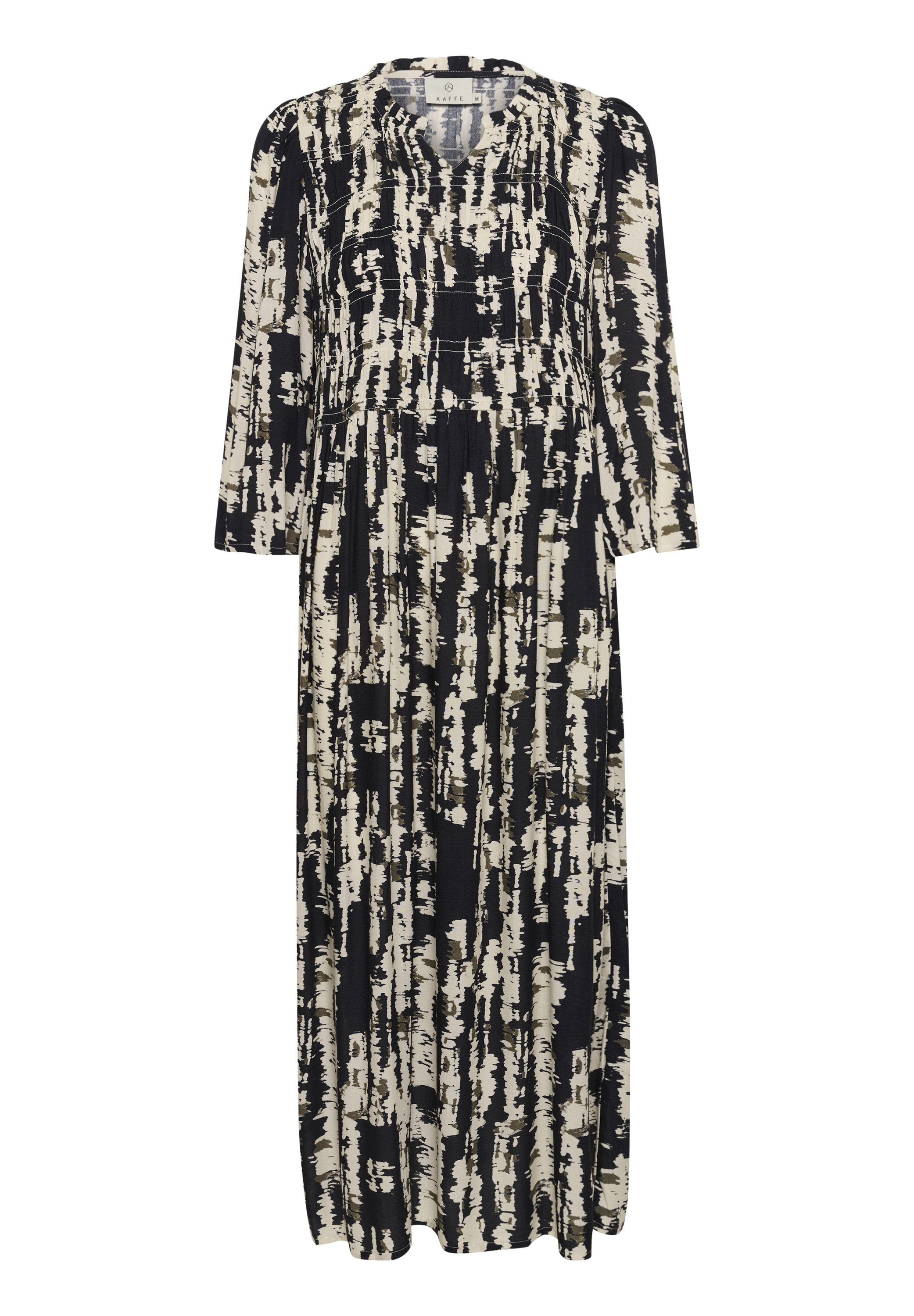 Maxikleid in Schwarz und Creme, mit einem Pinselstrichmuster. Lange Ärmel, runder Ausschnitt und geraffte Details in der Taille.