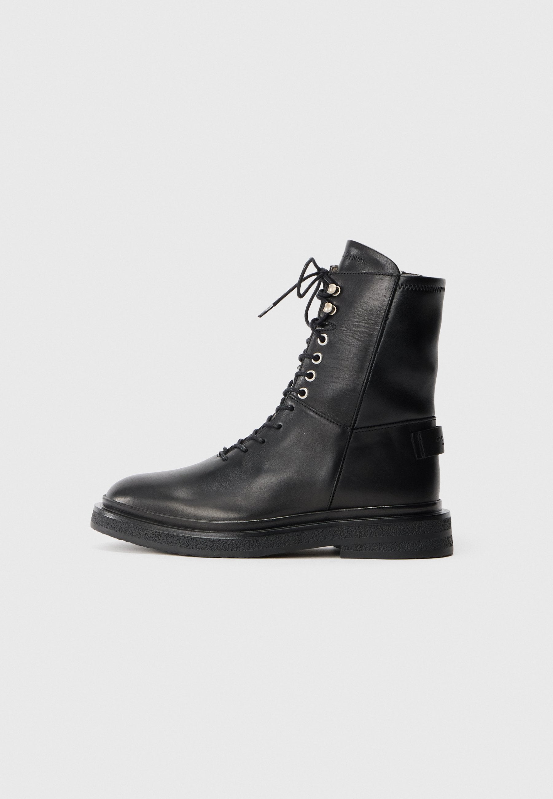 Schwarze Leder-Ankle-Boots mit Schnürung, silbernen Ösen, strukturiertem schwarzen Gummisohle und gepolsterter Lasche für zusätzlichen Komfort.