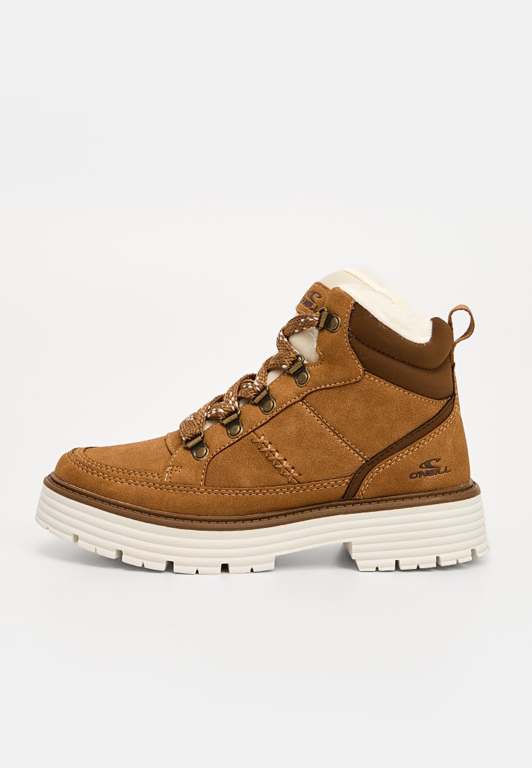 Braune Wildleder-Stiefeletten mit weißer Gummisohle, Kunstpelzfutter und metallischen Ösen für die Schnürsenkel. Nähte als Akzent an der Seite.